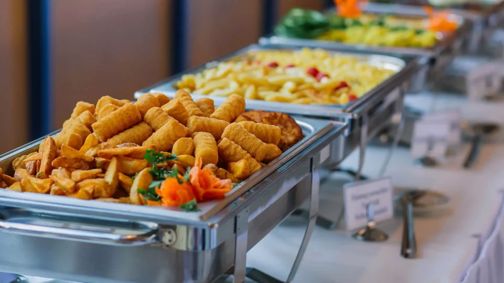 Ein reichhaltiges Buffet mit goldbraunen Snacks und buntem Gemüse im Vordergrund